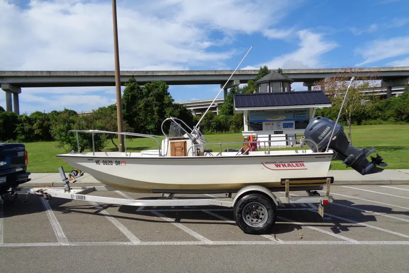 Slide: The Image of 1986 Boston Whaler Montauk 17 CC boat on trailer in parking lot. - 1