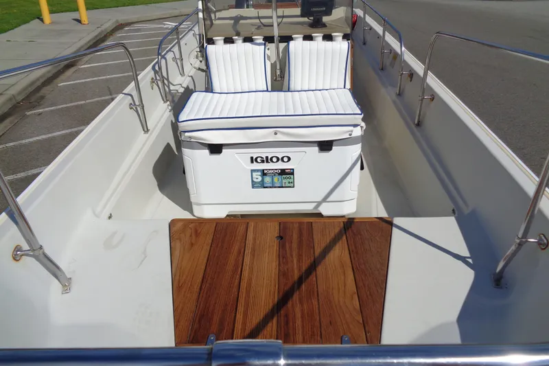 Slide: The Image of 1986 Boston Whaler Montauk 17 CC interior with Igloo cooler and wooden deck. - 10