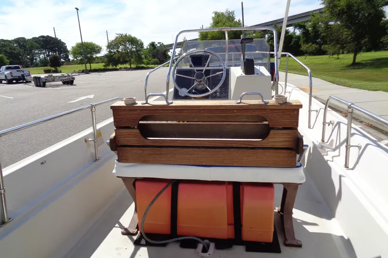 Slide: The Image of 1986 Boston Whaler Montauk 17 CC boat interior with steering wheel and wooden seating. - 15