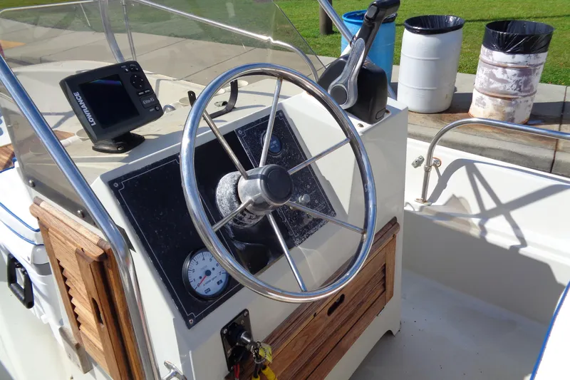 Slide: The Image of 1986 Boston Whaler Montauk 17 CC boat console with steering wheel and navigation equipment. - 17