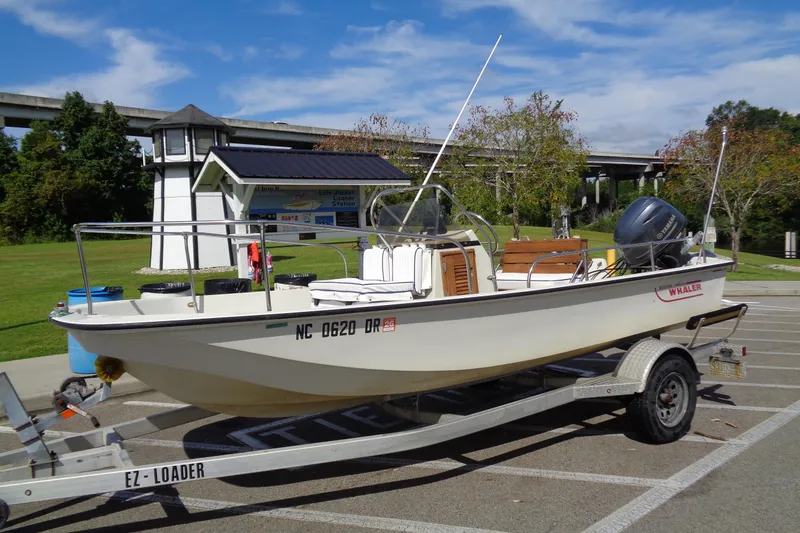 Slide: The Image of 1986 Boston Whaler Montauk 17 CC boat on trailer in a parking lot. - 2