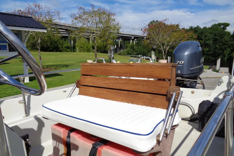 Slide: The Image of 1986 Boston Whaler Montauk 17 CC boat interior with wooden bench and outboard motor. - 6