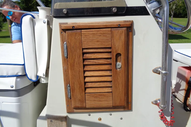 Slide: The Image of 1986 Boston Whaler Montauk 17 CC console with wooden storage compartment and seating. - 7