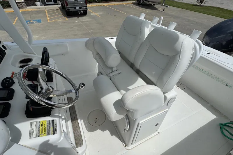 Slide: The Image of 2014 Sea Hunt Gamefish 25 boat interior with white seating and steering wheel. - 14