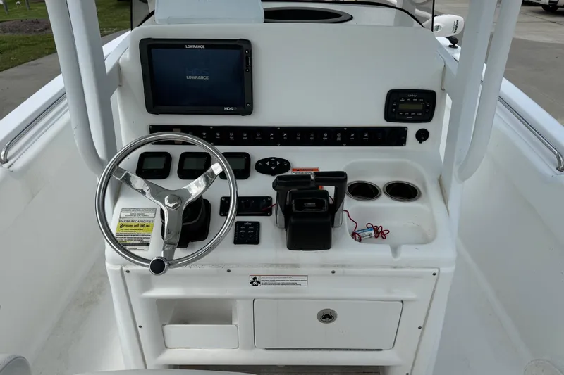 Slide: The Image of 2014 Sea Hunt Gamefish 25 console with steering wheel, controls, and navigation display. - 15