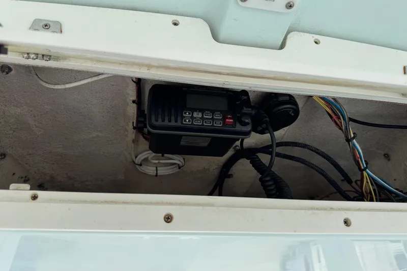 Slide: The Image of 2014 Sea Hunt Gamefish 25 boat electronics compartment with radio and wiring. - 17
