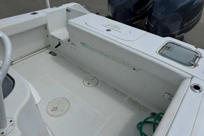Slide: The Image of 2014 Sea Hunt Gamefish 25 boat interior with Yamaha engines, featuring storage compartments. - 18