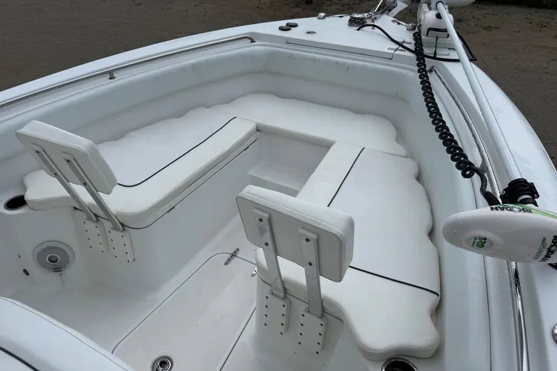 Slide: The Image of 2014 Sea Hunt Gamefish 25 boat interior with white cushioned seating and fishing equipment. - 23
