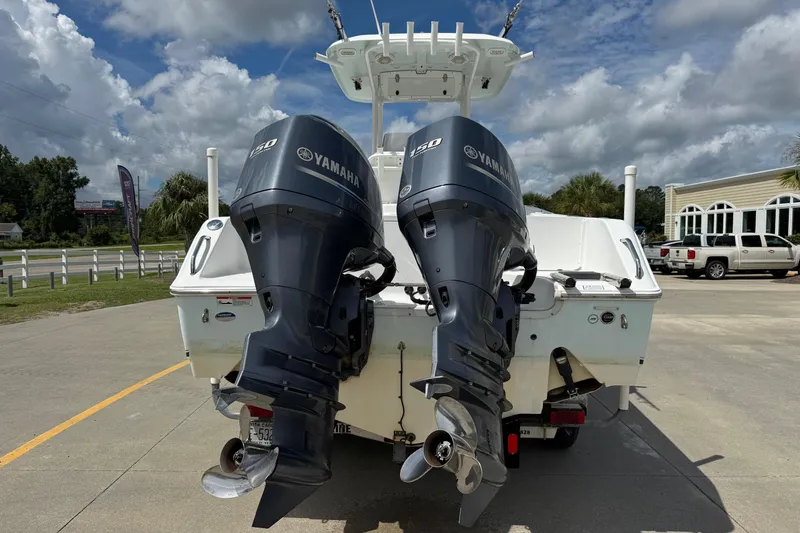 Slide: The Image of 2014 Sea Hunt Gamefish 25 with dual Yamaha 150 engines, parked outdoors. - 3