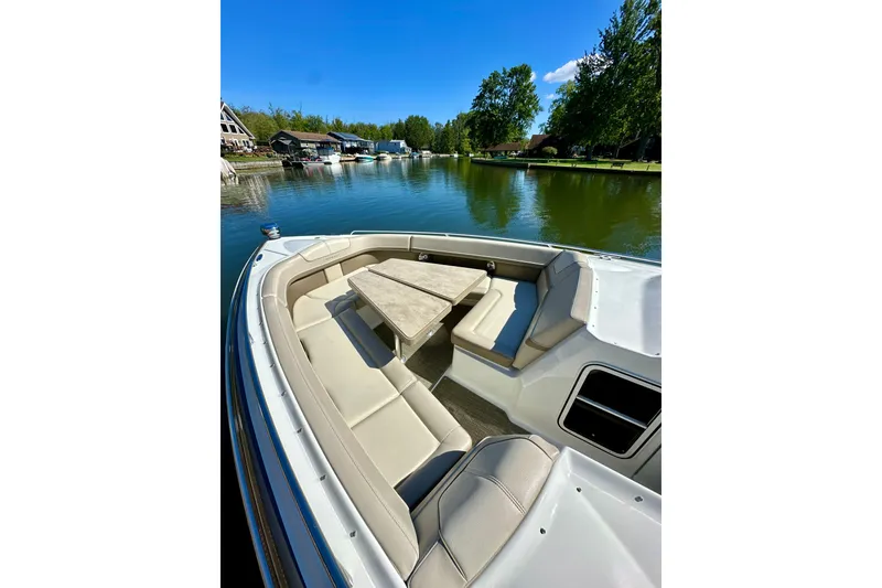 Slide: The Image of 2015 Formula 350 Crossover Bowrider I/O on a serene lake with spacious seating. - 23