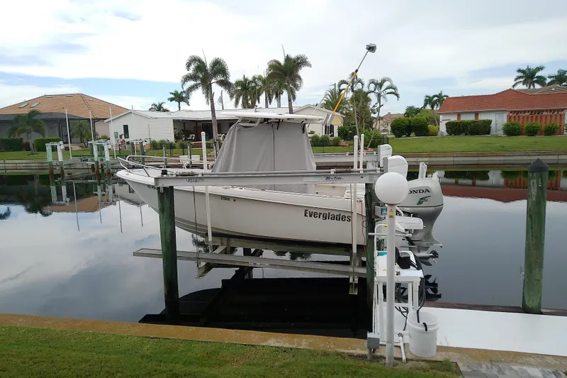 Slide: The Image of 2008 Everglades 210CC boat docked in a serene residential canal setting. - 1