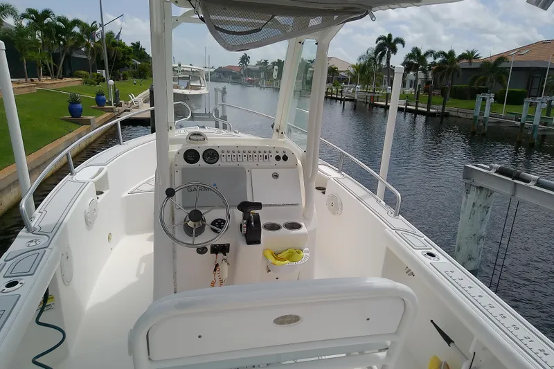 Slide: The Image of 2008 Everglades 210CC boat interior with steering wheel, docked by a canal. - 14