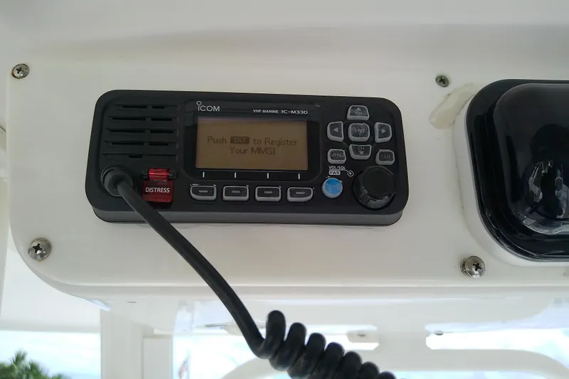 Slide: The Image of VHF marine radio on 2008 Everglades 210CC boat dashboard, featuring distress button. - 25