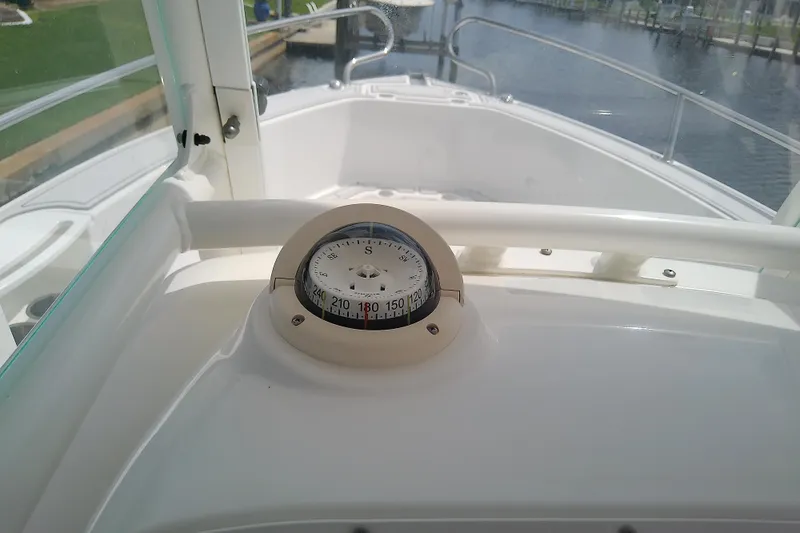 Slide: The Image of Compass on 2008 Everglades 210CC boat dashboard, overlooking calm waters. - 26