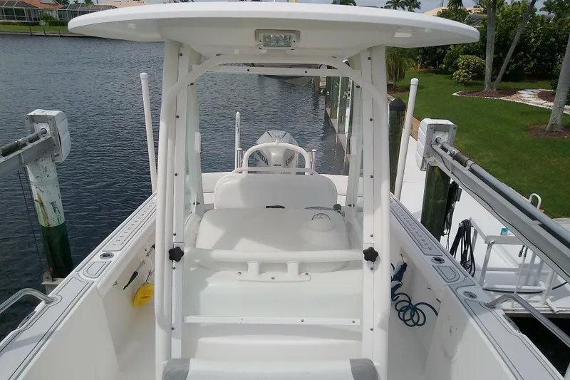 Slide: The Image of 2008 Everglades 210CC boat docked by a waterfront, featuring a white console and seating. - 29