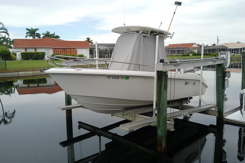 Slide: The Image of 2008 Everglades 210CC boat on lift, docked near waterfront homes. - 3