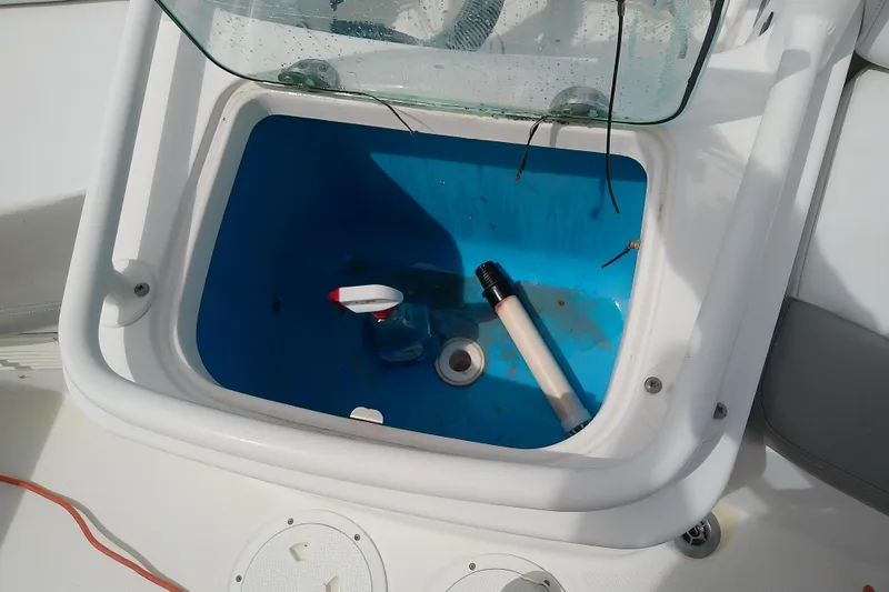 Slide: The Image of Open storage compartment on 2008 Everglades 210CC boat with cleaning supplies inside. - 33