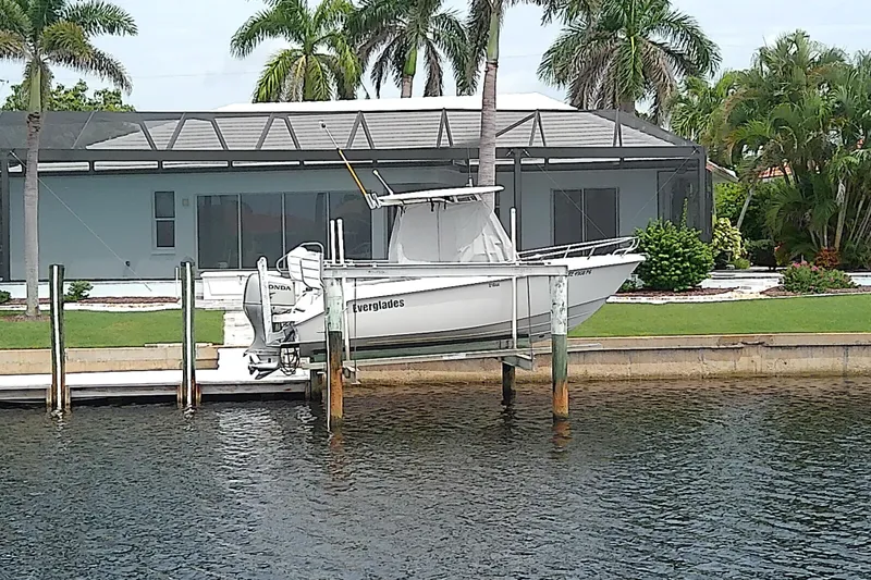 Slide: The Image of 2008 Everglades 210CC boat docked near waterfront home with palm trees. - 4