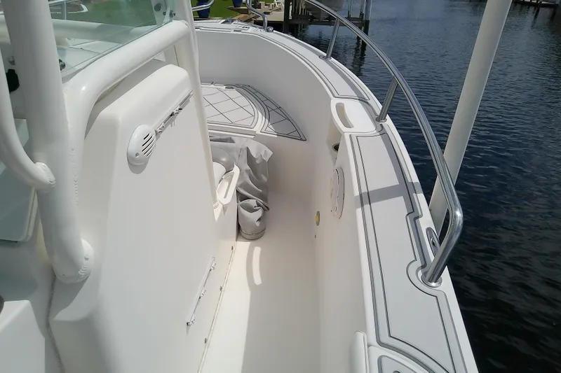 Slide: The Image of 2008 Everglades 210CC boat interior with white seating and railing by the water. - 40