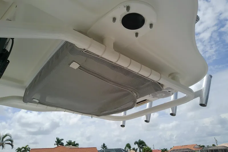 Slide: The Image of 2008 Everglades 210CC boat canopy with rod holders and storage net, under a cloudy sky. - 44