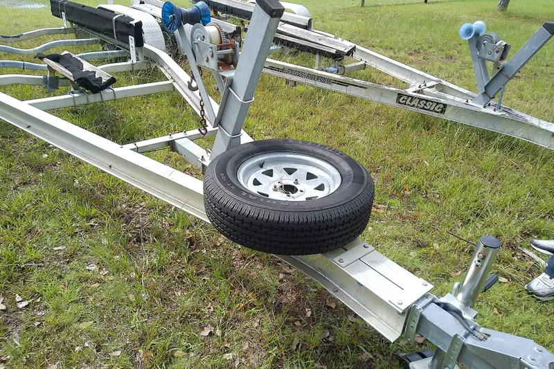 Slide: The Image of Boat trailer with spare tire on grass, compatible with 2008 Everglades 210CC model. - 51
