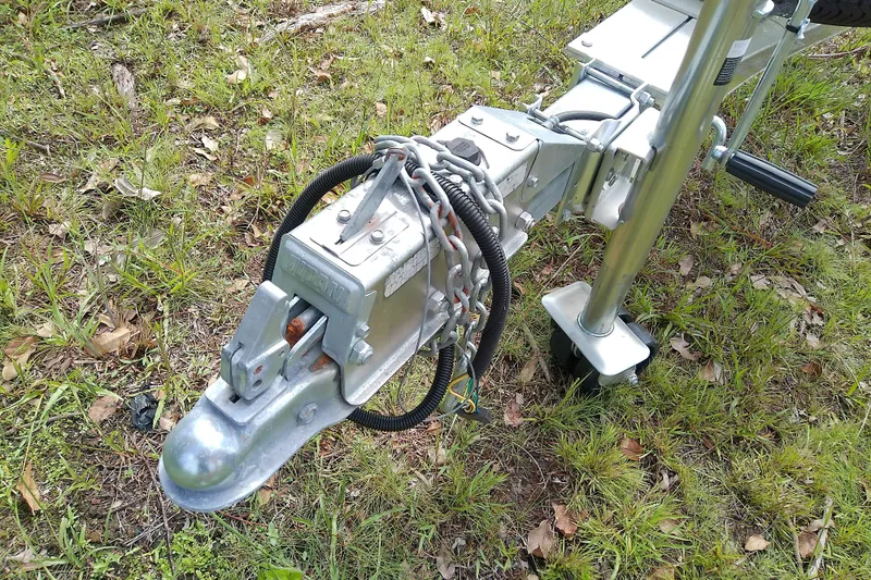 Slide: The Image of Trailer hitch of a 2008 Everglades 210CC boat on grassy ground. - 53