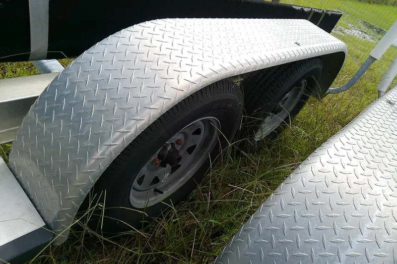 Slide: The Image of Trailer with diamond plate fenders and dual wheels, grass background. Everglades 210CC, 2008 model. - 54