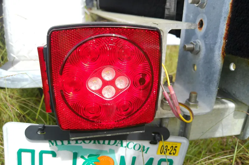 Slide: The Image of Red trailer tail light with Florida license plate, attached to Everglades 210CC boat trailer. - 55
