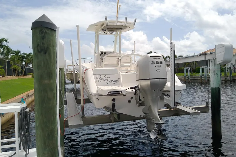 Slide: The Image of 2008 Everglades 210CC boat with Honda 225 VTEC engine on a lift by the water. - 9