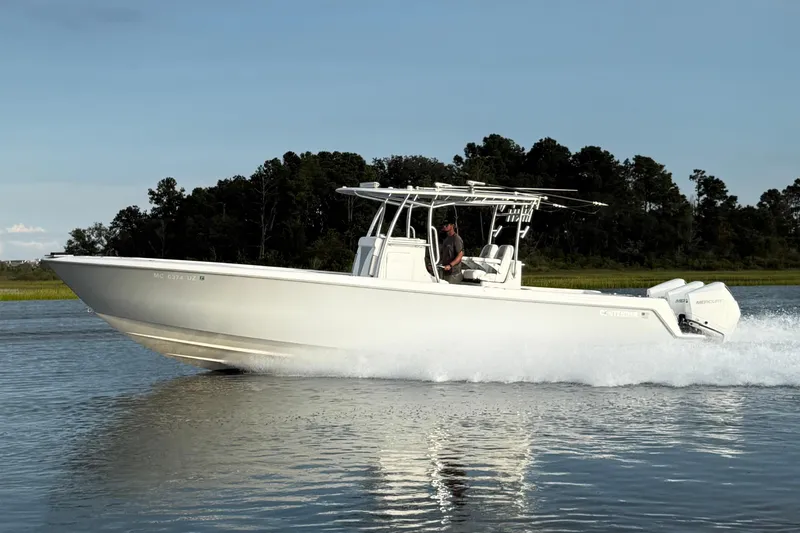 Slide: The Image of 2022 Contender 35 ST boat cruising on a calm lake with forested background. - 12