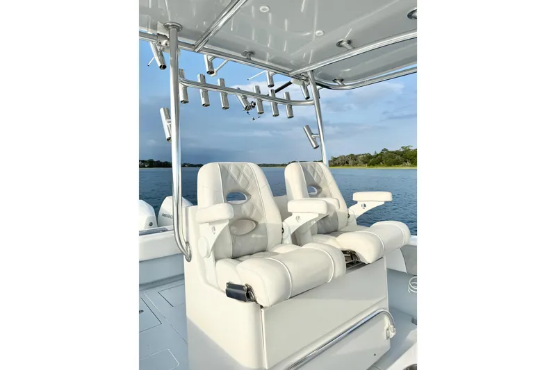 Slide: The Image of 2022 Contender 35 ST boat with luxurious white seating and rod holders on a calm lake. - 14