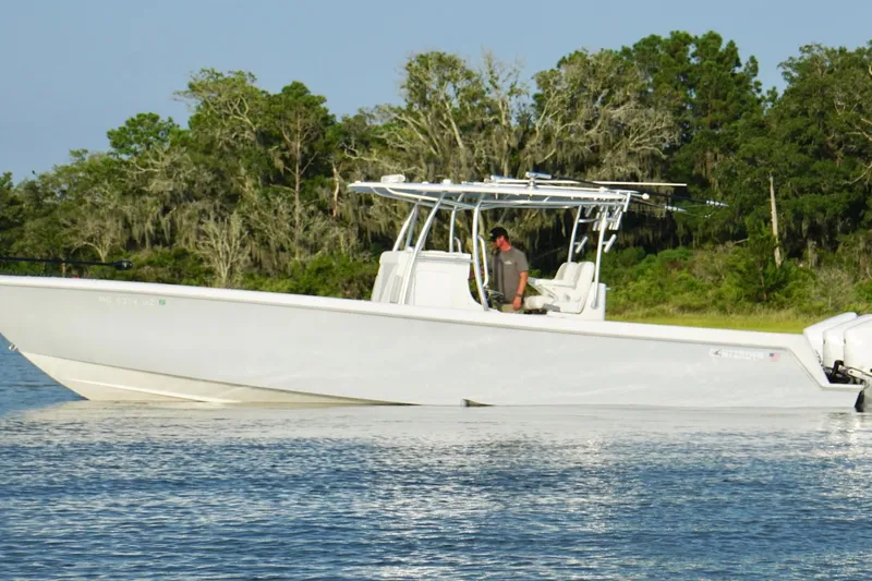 Slide: The Image of 2022 Contender 35 ST boat on calm water near lush green shoreline. - 3