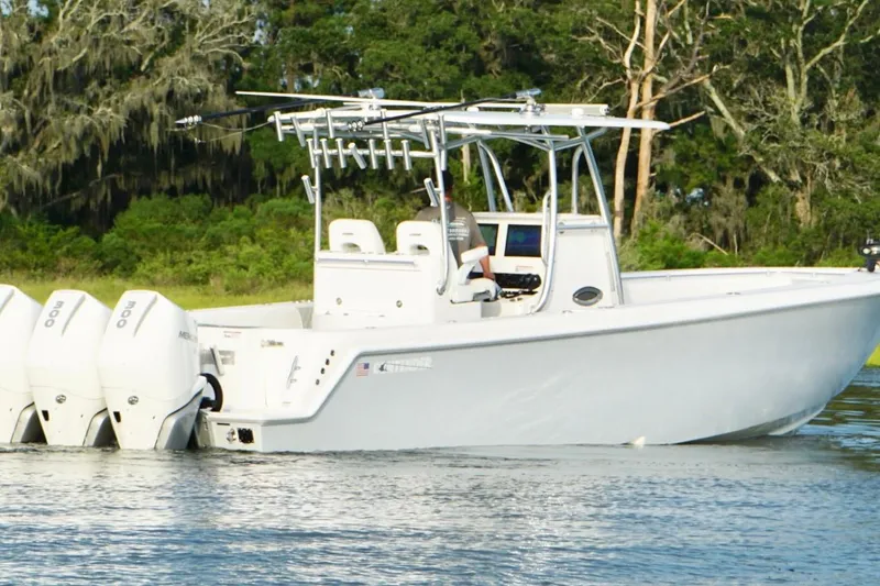 Slide: The Image of 2022 Contender 35 ST boat with triple outboard engines on a calm waterway. - 4