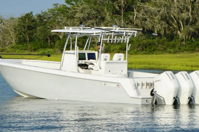 Slide: The Image of 2022 Contender 35 ST boat with triple outboard engines on a calm waterway. - 5