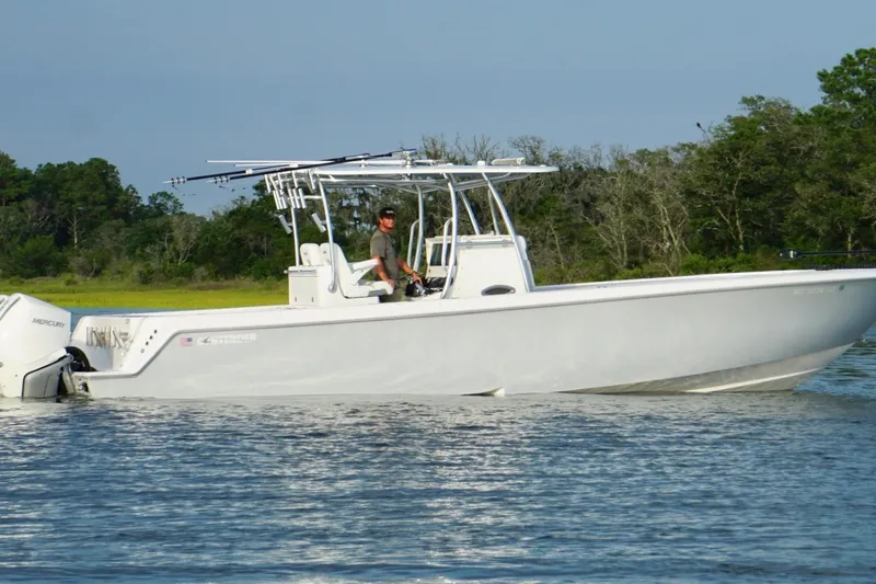 Slide: The Image of 2022 Contender 35 ST boat on water, with Mercury engines, near lush green shoreline. - 6