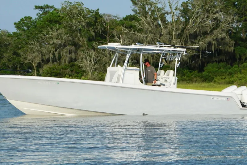Slide: The Image of 2022 Contender 35 ST boat on calm water, surrounded by lush greenery. - 7