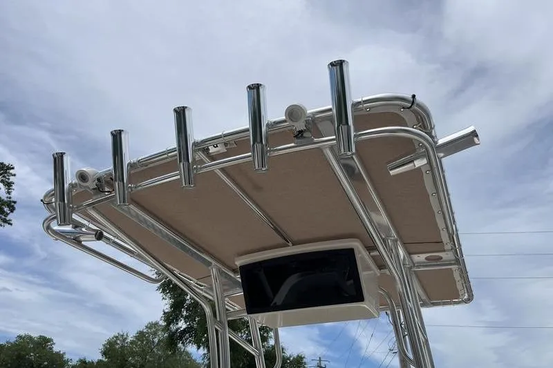 Slide: The Image of T-top of 2025 Pioneer 202 Sportfish boat with rod holders against cloudy sky. - 11