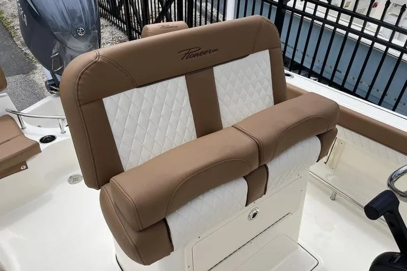 Slide: The Image of 2025 Pioneer 202 Sportfish boat with tan and white cushioned seating. - 13