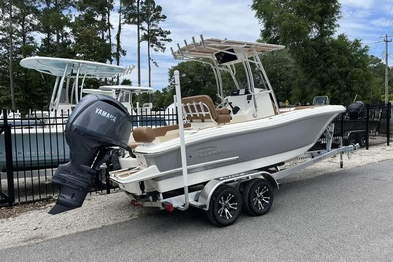 Slide: The Image of 2025 Pioneer 202 Sportfish boat on trailer with Yamaha outboard motor, parked outdoors. - 2