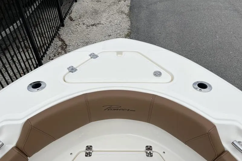 Slide: The Image of 2025 Pioneer 202 Sportfish boat bow with tan seating and storage compartment. - 7