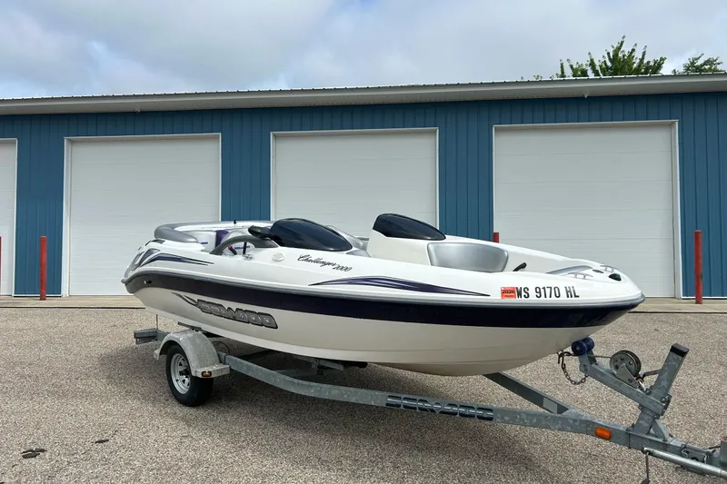 Slide: The Image of 2003 Sea Doo Challenger 2000 boat on trailer, parked in front of blue garage doors. - 24