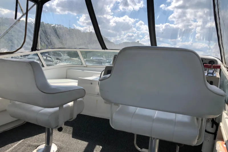 Slide: The Image of Interior of 2001 Carver 374 Voyager yacht with white seating and panoramic windows. - 10