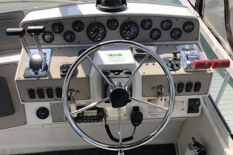 Slide: The Image of 2001 Carver 374 Voyager helm with steering wheel, gauges, and control levers. - 13
