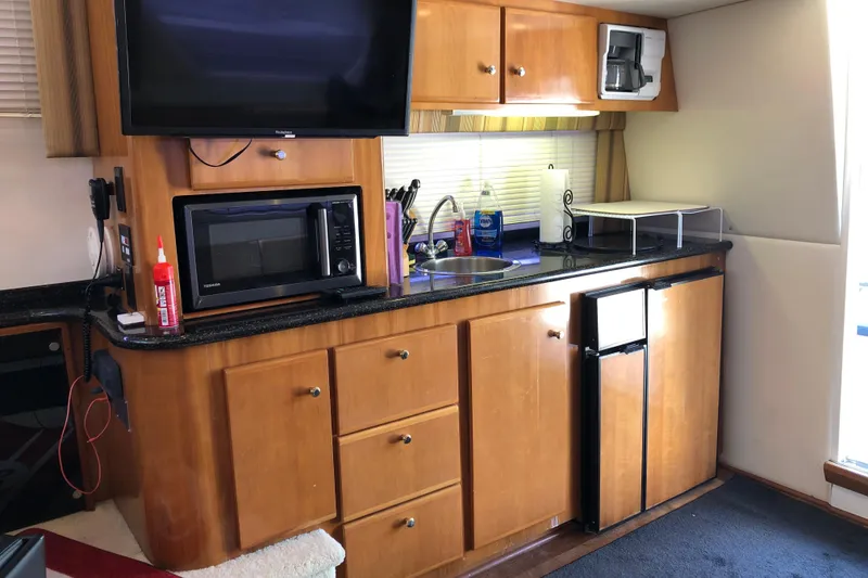 Slide: The Image of 2001 Carver 374 Voyager kitchen with wooden cabinets, microwave, sink, and mini fridge. - 17