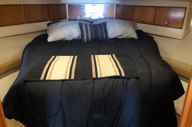Slide: The Image of Cozy bedroom in 2001 Carver 374 Voyager yacht with plush bedding and wooden cabinets. - 24