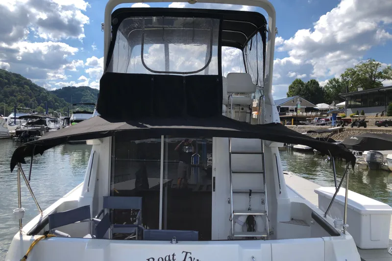 Slide: The Image of 2001 Carver 374 Voyager docked at marina, featuring upper deck and ladder. - 5