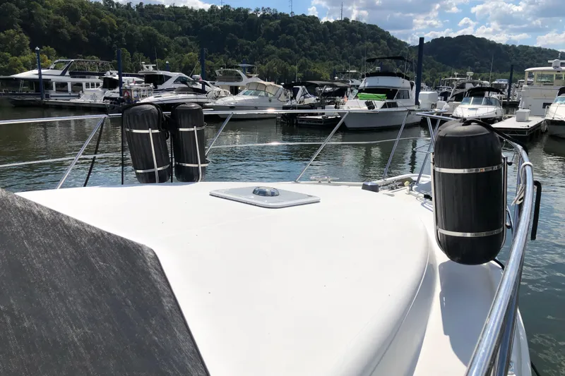 Slide: The Image of 2001 Carver 374 Voyager yacht docked at marina with scenic background. - 6