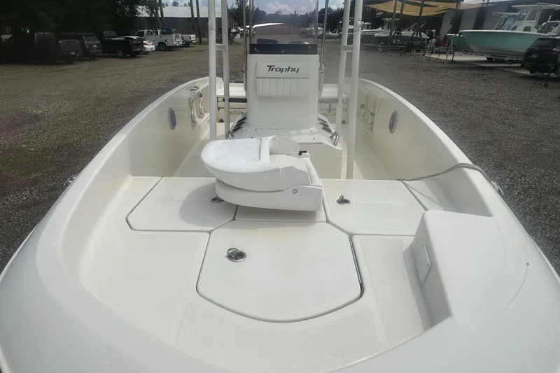 Slide: The Image of 2022 Trophy T-18 boat interior with seating and storage, parked outdoors. - 10