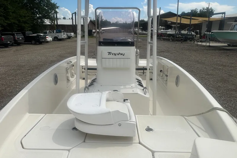 Slide: The Image of 2022 Trophy T-18 boat interior with seating and console, parked outdoors. - 11