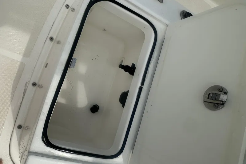 Slide: The Image of Open storage compartment on a 2022 Trophy T-18 boat, featuring a secure latch. - 17